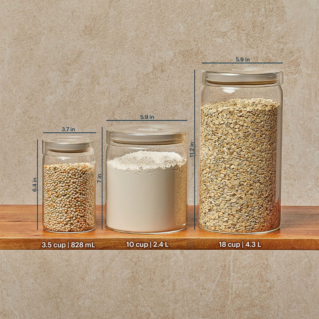 Three glass jars with different contents and measurements on a wooden shelf against a beige wall.