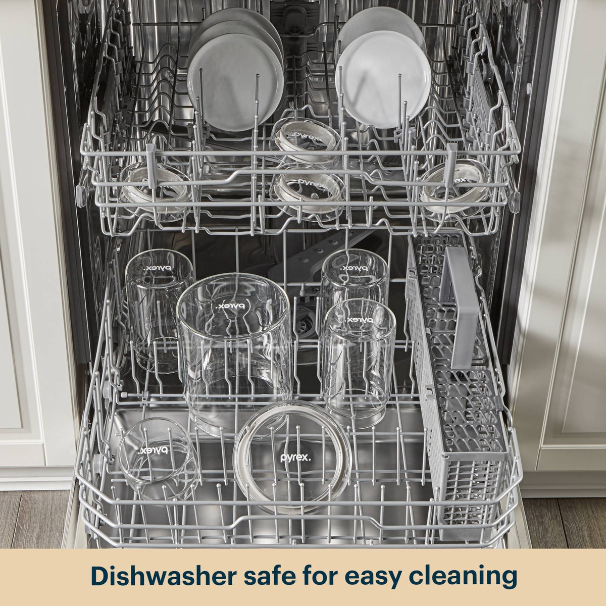 Dishwasher with clean dishes including Pyrex glasses and bowls.
