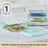 Glass bakeware set with food on a table, featuring a brand logo and text about variety of sizes.