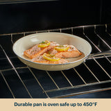 Salmon fillets with lemon slices in a pan inside an oven, with text indicating oven safety.