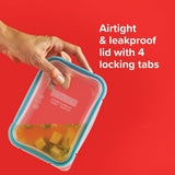 Hand holding a clear food container with a blue lid against a red background, featuring text about the container's features.