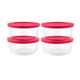 Set of four clear glass food storage containers with pink lids on a white background
