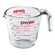 Pyrex measuring cup with red measurement markings on a white background