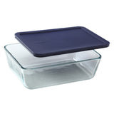 Clear glass food storage container with a navy blue lid on a white background